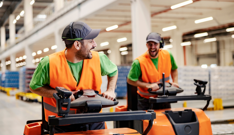 Jonge flexkrachten lachen aan het werk in een magazijn